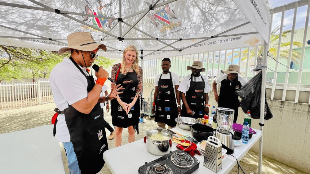 The MGEPESW team explains to the judge, Miss Universe 1992 Michelle McLean, what they are going to cook.