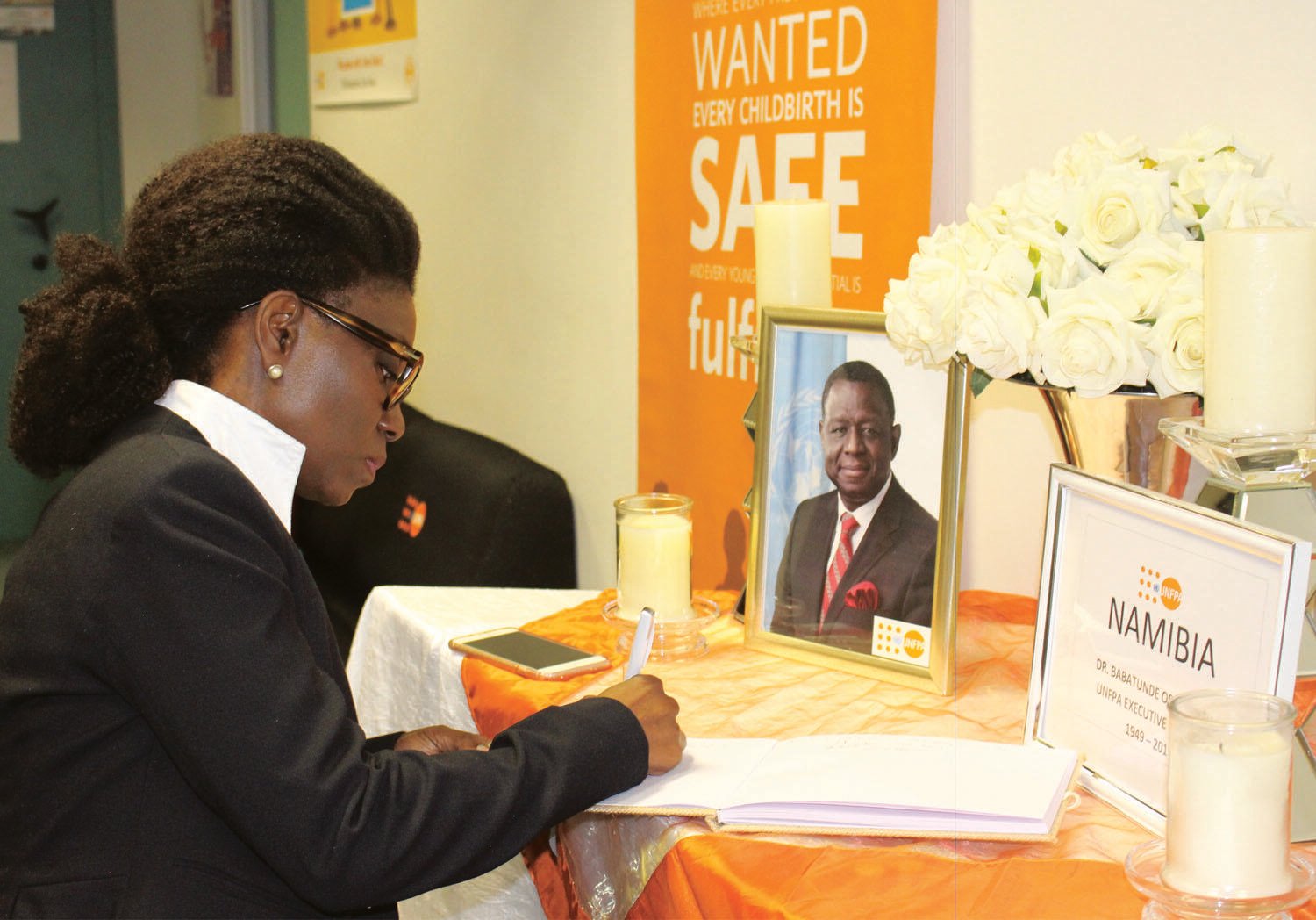 Ms. Kiki Ghebo, UN Namibia Resident Coordinator, signs a book of condolence for Dr. Osotimehin.  (Photo: UNFPA Namibia/Emma Mbekele)