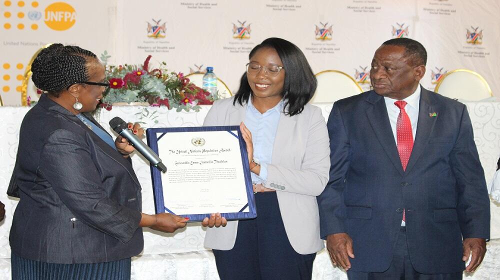 Hon. Theofelus (middle) receives the 2022 United Nations Population Award from Ms. Roseau, UNFPA Namibia Representative.